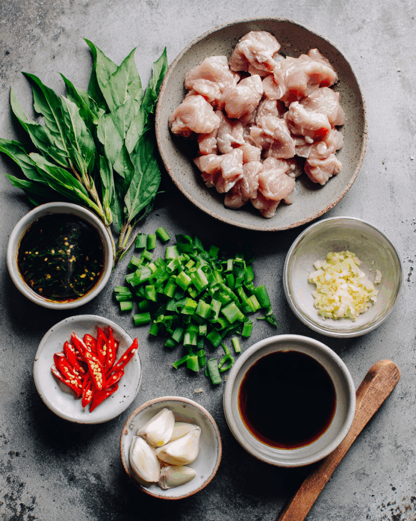 Stir frying Thai chilli basil chicken with garlic and chillies