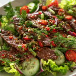 Thai Beef Salad close-up with herbs and dressing
