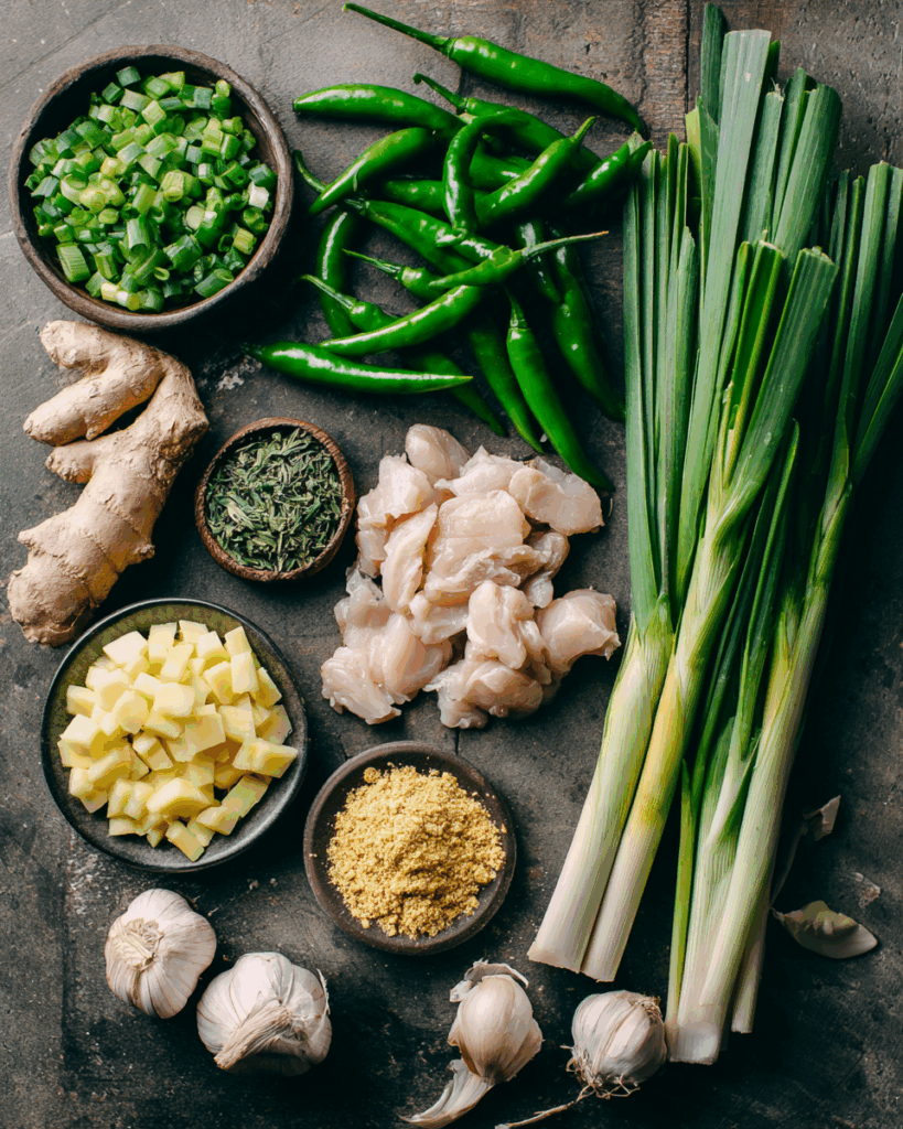 Fresh ingredients for Thai green curry paste on a wooden board