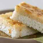 Sticky Rice Layer Cake with pink and white layers on Thai-style plate