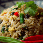 Authentic Thai Olive Fried Rice with prawns, egg, and lime garnish