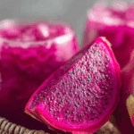 Vibrant Thai dragon fruit juice served in a glass with lime and dragon fruit garnish