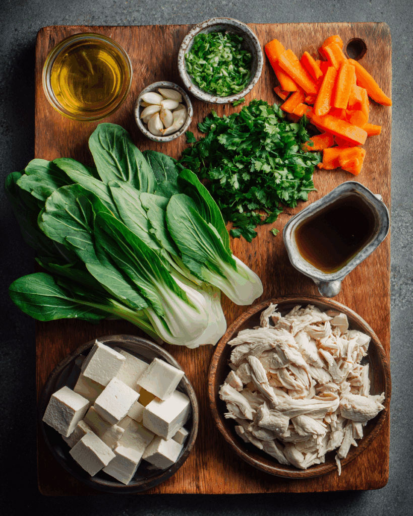 Flat lay of fresh ingredients for Thai clear soup with chicken and tofu.