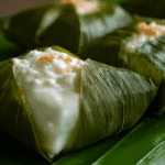 Coconut Cream Stuffed in Banana Leaves served on a wooden tray