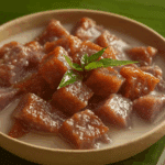 Thai Candied Taro in Coconut Milk served in a bowl with pandan leaves