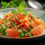 Authentic Thai Pomelo Salad served in a bowl with shrimp and herbs