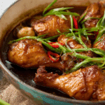 Thai Braised Chicken with Soy Sauce served with jasmine rice and garnished with scallions.