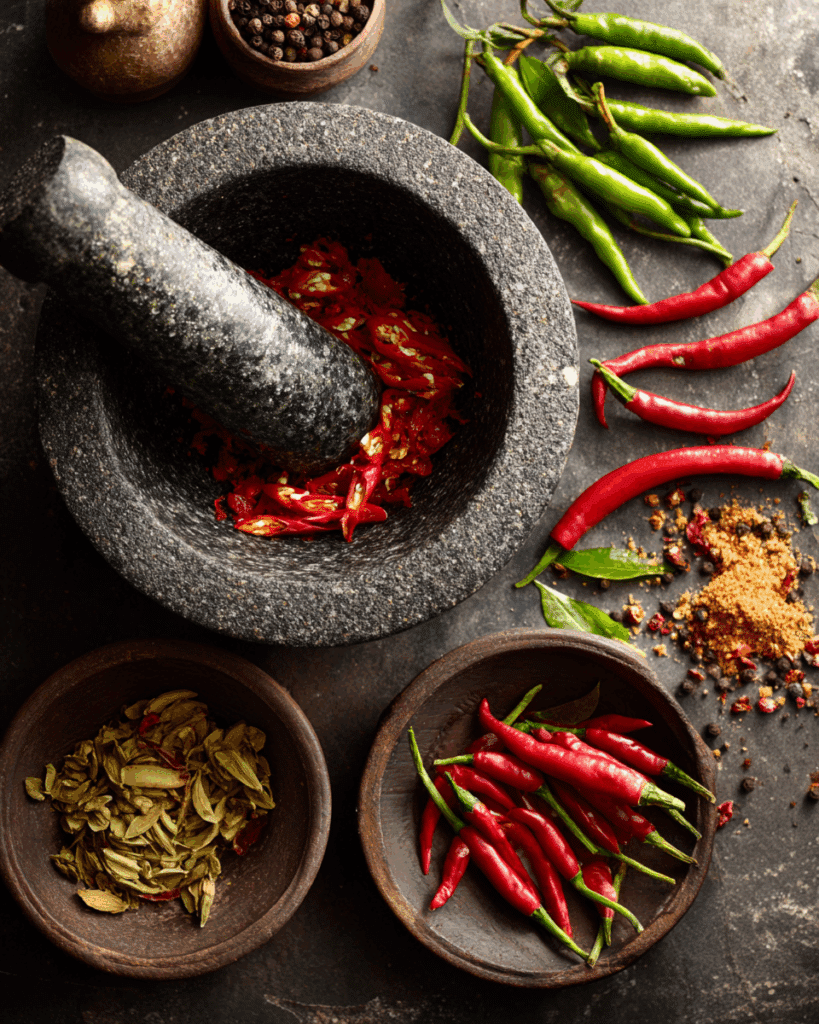 Blending homemade curry paste with Thai herbs and spices.