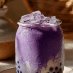 Homemade Taro Milk Tea Boba in a clear glass with pearls.