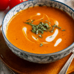 Creamy Thai Tomato Soup Recipe with cilantro and coconut swirl.