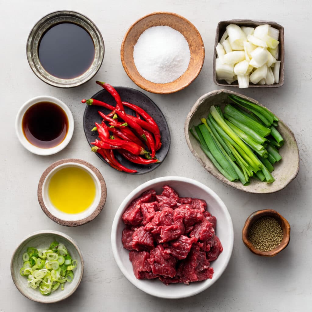 Ingredients for Thai Chili Beef Recipe including sliced beef, Thai chilies, garlic, soy sauce, and oyster sauce